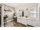 Stylish bathroom with decorative wallpaper, a vanity, and a large mirror at 5668 S Foresthill St, Littleton, CO 80120