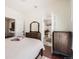 Bedroom featuring wood floors, a dresser and views into an ensuite bathroom at 5668 S Foresthill St, Littleton, CO 80120