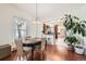 Charming dining room boasts hardwood floors, a stylish chandelier, and an open view of the kitchen at 5668 S Foresthill St, Littleton, CO 80120