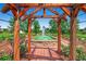 Framed view of a peaceful water fountain surrounded by lush greenery, seen through a wooden pergola at 5668 S Foresthill St, Littleton, CO 80120