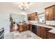 Inviting kitchen featuring wood cabinets, tile flooring, and a view into the adjacent living space at 5668 S Foresthill St, Littleton, CO 80120