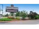 Eye-level view of Hudson Gardens & Event Center sign with lush landscaping and a clear blue sky as a backdrop at 5668 S Foresthill St, Littleton, CO 80120