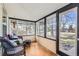 Cozy sunroom with wicker furniture, wood floors, and ample natural light through large windows at 5668 S Foresthill St, Littleton, CO 80120