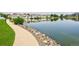 Scenic community pond with walking path, lush green grass, and neighborhood homes in the background at 15555 E 40Th Ave # 11, Denver, CO 80239