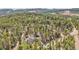 Stunning aerial view of a home nestled within a dense forest, showcasing privacy and natural beauty in a mountain setting at 10887 Goodheart Ave, Conifer, CO 80433