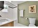 Bathroom featuring hexagon tile flooring, toilet, and green walls with an artistic print at 10887 Goodheart Ave, Conifer, CO 80433