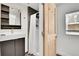 Modern bathroom features a stylish floating vanity, tiled shower, and light wood door, blending function with minimalist design at 10887 Goodheart Ave, Conifer, CO 80433