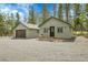 Charming home with a detached garage and a gravel driveway surrounded by trees at 10887 Goodheart Ave, Conifer, CO 80433