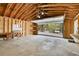 Spacious garage featuring a large open door, concrete floor, work bench, and ample storage shelves at 10887 Goodheart Ave, Conifer, CO 80433
