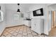 Compact kitchen with white cabinets, modern appliances, and an adjacent dining area at 10887 Goodheart Ave, Conifer, CO 80433