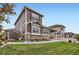 The spacious backyard showcases the home's exterior, covered patio, and lush green lawn at 8953 Falcon St, Firestone, CO 80504