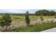 A view of the backyard featuring a lush lawn, white fence, and neighboring fields at 8953 Falcon St, Firestone, CO 80504