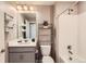 This bathroom features a shower-tub combo, a vanity and a shelving unit for storage at 8953 Falcon St, Firestone, CO 80504