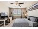 Bedroom featuring a ceiling fan, desk, and comfortable bed with scenic artwork at 8953 Falcon St, Firestone, CO 80504