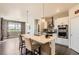 Bright kitchen featuring an island with bar seating, pendant lighting, and stainless steel appliances at 8953 Falcon St, Firestone, CO 80504