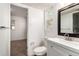 Cozy bathroom featuring white vanity, mirror, toilet, and a view into another room at 1151 Revere St, Aurora, CO 80011