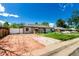 Exterior view of a single-story home featuring a driveway and a small, fenced front yard at 1151 Revere St, Aurora, CO 80011