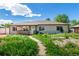 Charming single-story home featuring a cozy porch and a spacious front yard with lush greenery at 1151 Revere St, Aurora, CO 80011