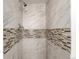Modern shower with sleek marble-patterned tiles and decorative accent band at 1151 Revere St, Aurora, CO 80011