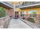 Condo entrance with brick accents, large windows, a well-kept walkway, and manicured landscaping at 9079 E Panorama Cir # 419, Englewood, CO 80112
