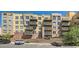 A full, low-angle exterior view of a condominium complex with multi-level balconies, brick accents, and parking at 9079 E Panorama Cir # 419, Englewood, CO 80112