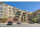 Multi-story condominium building with balconies, brick accents, and a parking lot in front on a sunny day at 9079 E Panorama Cir # 419, Englewood, CO 80112