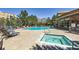 Outdoor pool area with sun loungers, landscaping, and a nearby brick clubhouse at 9079 E Panorama Cir # 419, Englewood, CO 80112