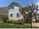 Back of home with gray siding, lawn, and young maple tree at 1160 S Fultondale Ct, Aurora, CO 80018