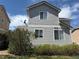 Rear exterior with gray siding, green grass, and mature bushes at 1160 S Fultondale Ct, Aurora, CO 80018