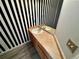 Bathroom with striped wall, wooden cabinet, and modern fixtures at 1160 S Fultondale Ct, Aurora, CO 80018