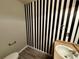 Bathroom with striped accent wall, commode, and countertop with sink at 1160 S Fultondale Ct, Aurora, CO 80018