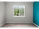 Bright bedroom with laminate floors, a blue accent wall and a large window overlooking a green yard at 1160 S Fultondale Ct, Aurora, CO 80018