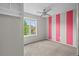Cozy bedroom with a window view and unique striped accent wall for added charm at 1160 S Fultondale Ct, Aurora, CO 80018