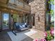 Covered back patio with stone accents, a porch swing and decorative string lights at 6995 S Ensenada St, Aurora, CO 80016