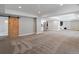 Basement with sliding barn door features neutral carpet and recessed lighting at 6995 S Ensenada St, Aurora, CO 80016