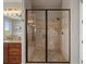 Luxurious shower with tile surround, seat, and glass doors in bathroom with granite counters at 6995 S Ensenada St, Aurora, CO 80016
