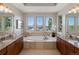 Luxury bathroom featuring a soaking tub, granite countertops, and dual vanities with large windows at 6995 S Ensenada St, Aurora, CO 80016
