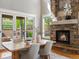 Sunlit dining room with stone fireplace, wood floors, and views of the outdoor patio at 6995 S Ensenada St, Aurora, CO 80016