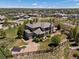 An exterior, aerial view of a spacious home with professional landscaping, a fenced-in yard, and a beautiful view at 6995 S Ensenada St, Aurora, CO 80016