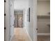 Hallway with tile floors leading to a glass enclosed shower and walk-in closet with shelving at 6995 S Ensenada St, Aurora, CO 80016