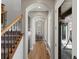Hallway with arched doorways leading to stairwell, front door, and light-filled rooms at 6995 S Ensenada St, Aurora, CO 80016