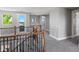 Upstairs hallway with neutral walls, wood and iron railing, and exterior access to a balcony at 6995 S Ensenada St, Aurora, CO 80016
