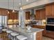 Gourmet kitchen featuring a large island with seating, stainless steel appliances, and custom cabinetry at 6995 S Ensenada St, Aurora, CO 80016