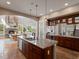 A gourmet kitchen featuring a large island with seating and seamless access to the living and dining areas at 6995 S Ensenada St, Aurora, CO 80016
