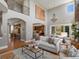 Open-concept living room featuring a fireplace, hardwood floors, and seamless access to the kitchen and outdoor patio at 6995 S Ensenada St, Aurora, CO 80016