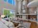Spacious living room with cathedral ceilings, a stone fireplace, large windows, and hardwood floors at 6995 S Ensenada St, Aurora, CO 80016