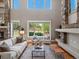 Bright living room with a stone fireplace, soaring windows, and a neutral color palette creating a welcoming atmosphere at 6995 S Ensenada St, Aurora, CO 80016