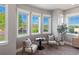 Bright sitting area with three large windows, plush chairs, and view to a manicured outdoor space at 6995 S Ensenada St, Aurora, CO 80016