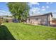 Backyard featuring a green lawn, a playground, dog run, mature trees, and fencing at 2311 W 46Th Ave, Denver, CO 80211