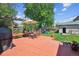 Landscaped backyard with a red wood deck, outdoor seating, a lush green lawn, and mature trees at 2311 W 46Th Ave, Denver, CO 80211